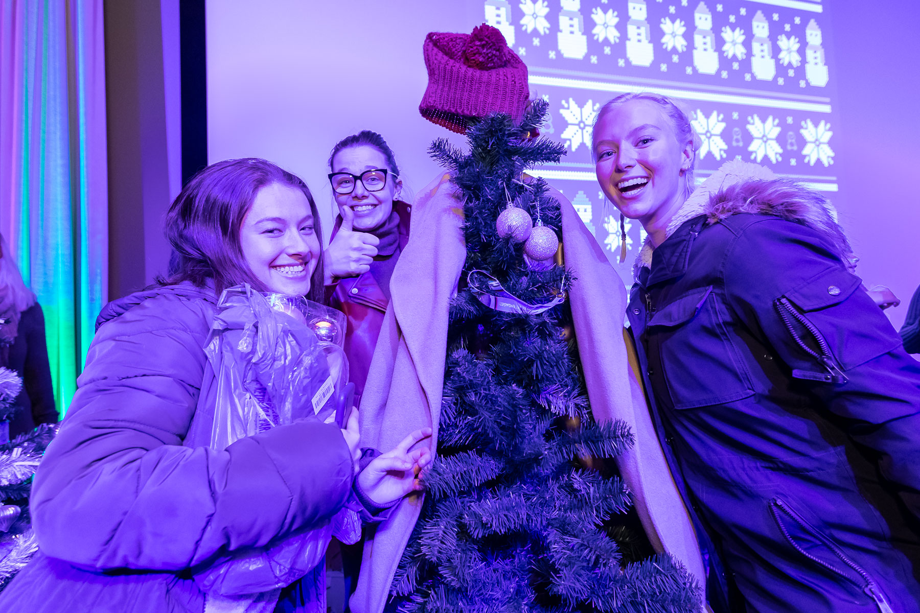 Students try their best to decorate a Christmas tree for the tree decorating contest at the Ugly Sweater Party. (DePaul University/Jeff Carrion)